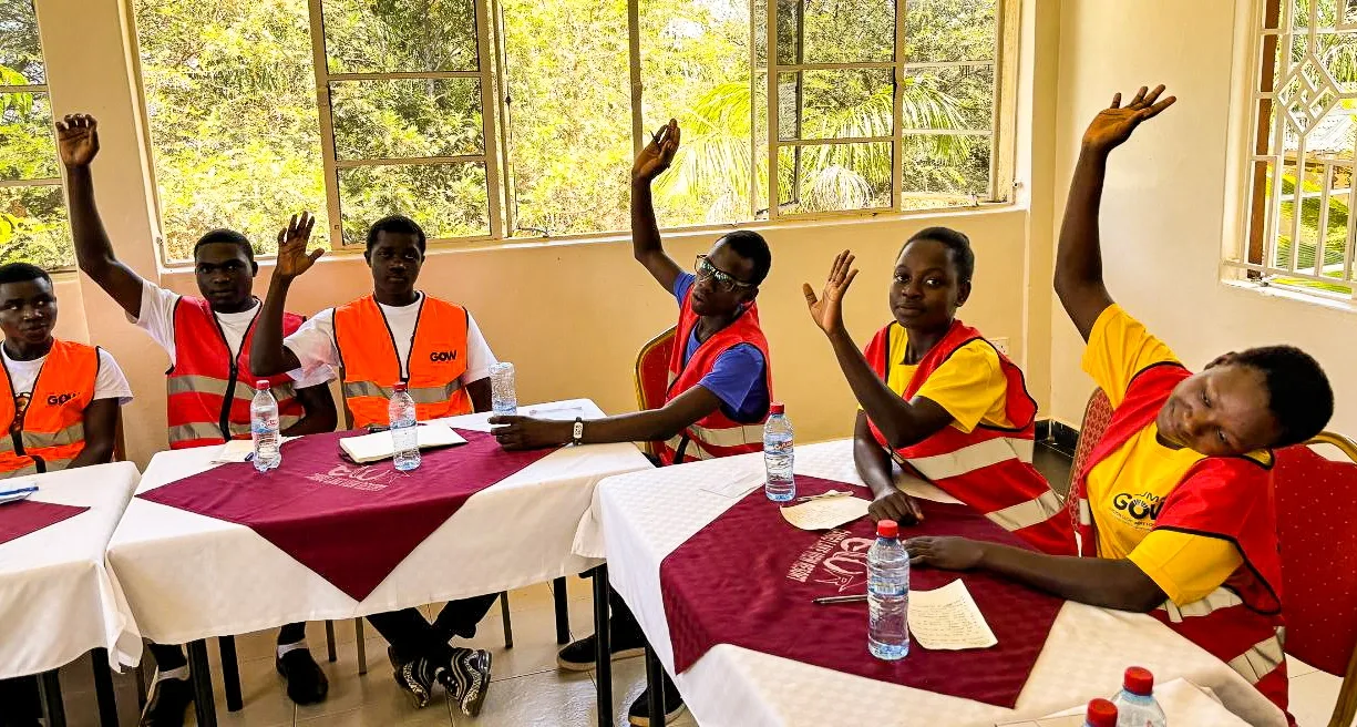 Students on education scholarships in Kenya raising their hands at a GOW Foundation workshop